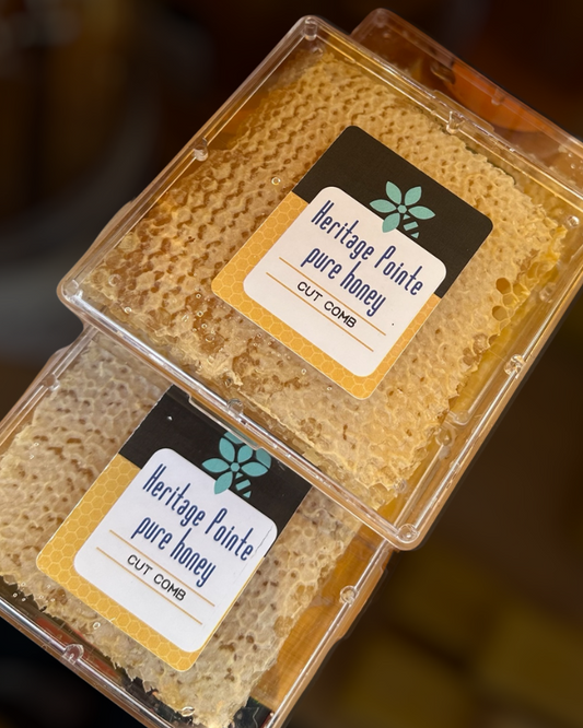 Two containers of Heritage Pointe pure honey with visible labels.